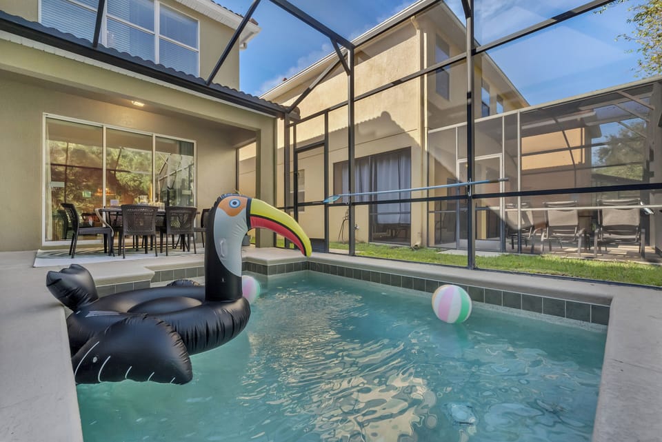 Refreshing swimming pool with inflatables in a glass enclosure