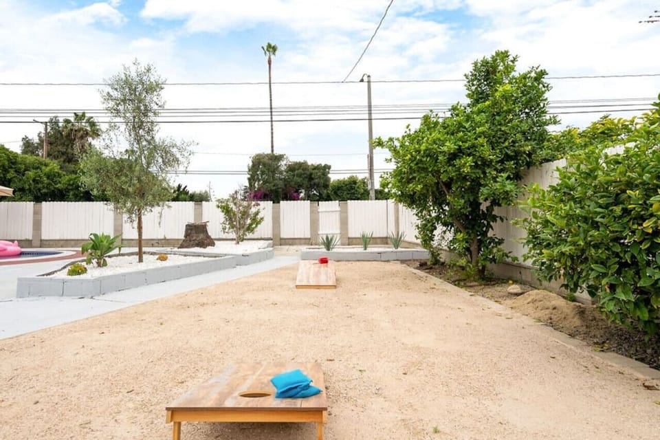 Enjoy a fun game of corn hole in the backyard, with a well-maintained lawn and space for friendly competition and relaxation.