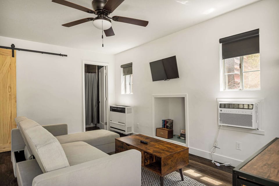 Living area with cozy seating and Smart TV. Wall heater and AC unit for your comfort.