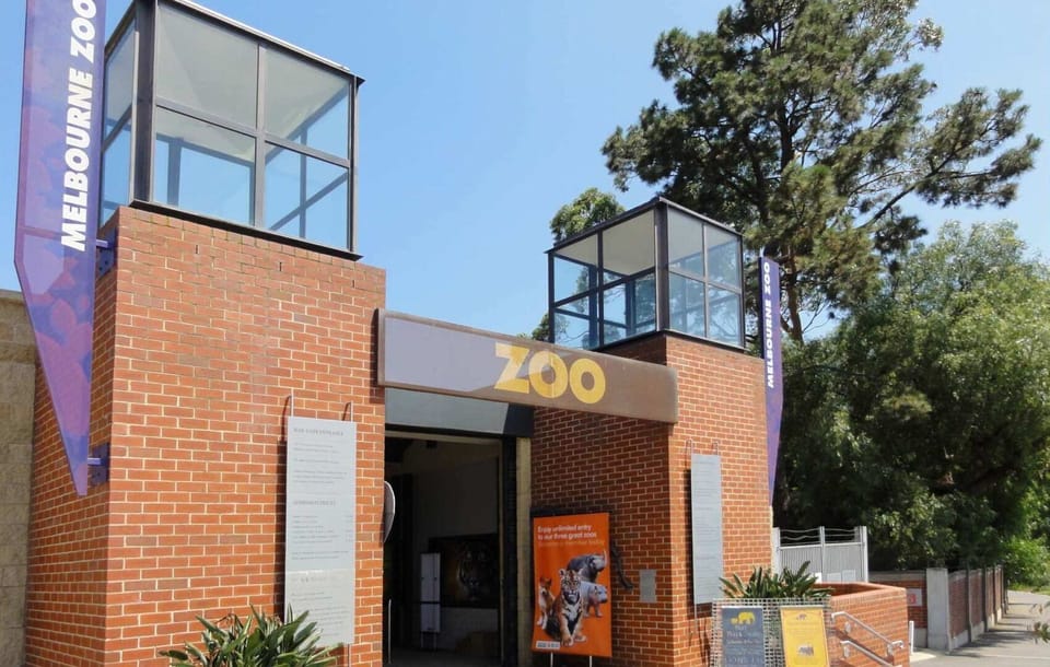 Secure brick apartment entry surrounded by greenery in a quiet residential setting.