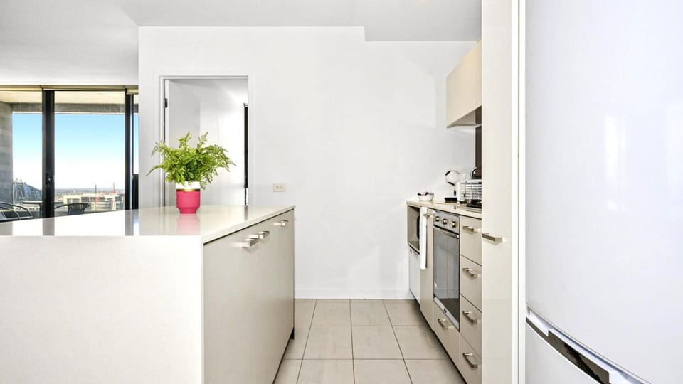 Seamless transitions and hidden storage for a clutter-free, airy kitchen