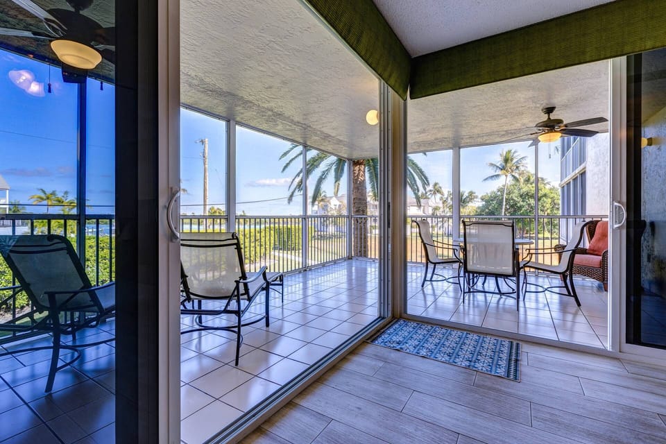 Enjoy a meal or drinks on the screened porch while taking in the serene water views, creating the perfect setting for relaxation.