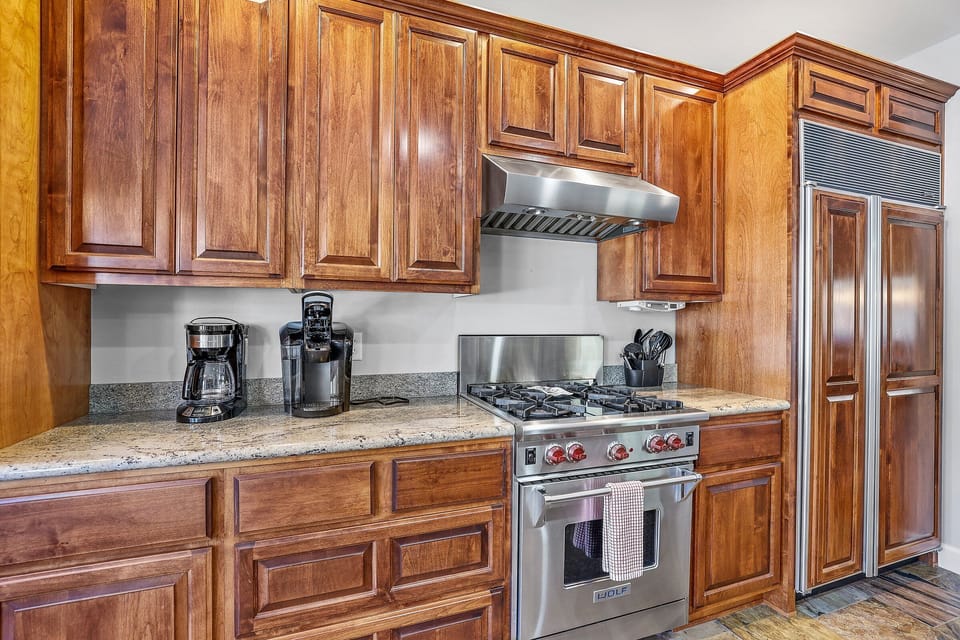 Modern appliances, including a Wolf gas range, double oven, standard and Keurig coffee machines.