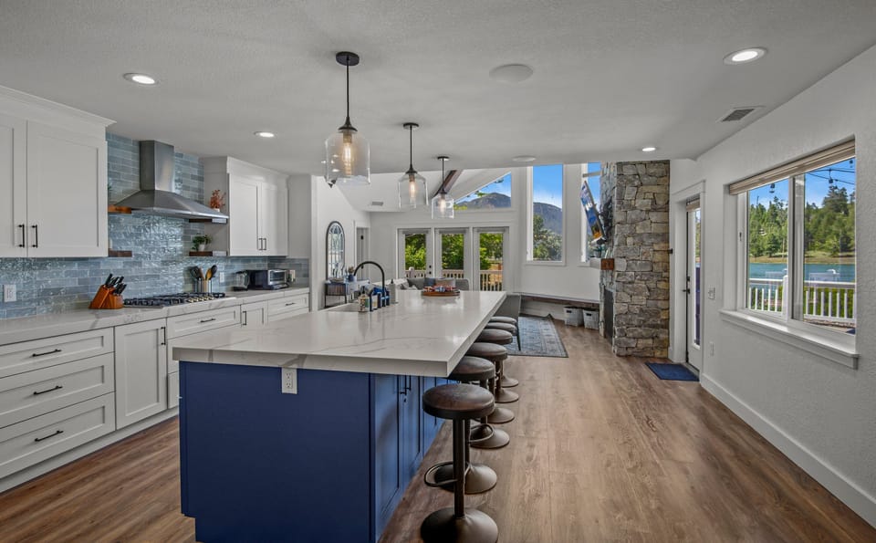 Blue subway tile and 6 barstools at the island top this kitchen off and make it the perfect place to create a meal with your friends and family.