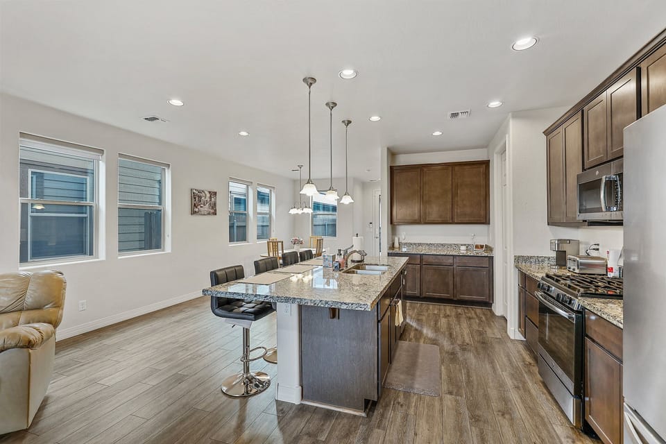 stainless steel appliances, a double sink, a dishwasher, and four slice toaster, kettle, Keurig, dark cabinetry and granite countertops