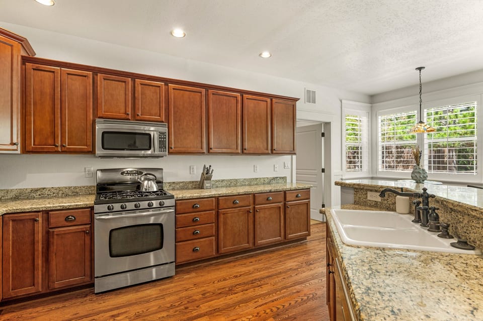 The kitchen features top-of-the-line stainless-steel appliances and granite countertops, with seating options for group meals.