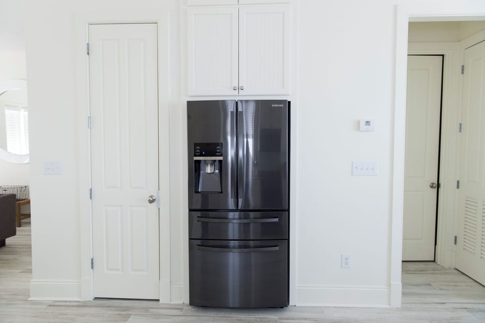 Brand new, spacious fridge with the half bathroom tucked away off of the kitchen