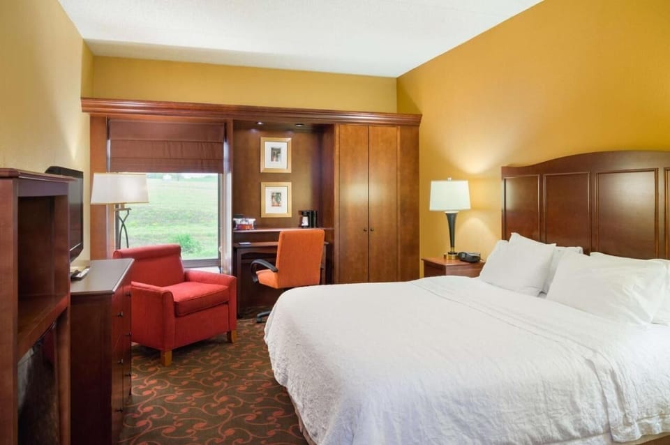 Unwind in a spacious suite with desk, armchair, and view.