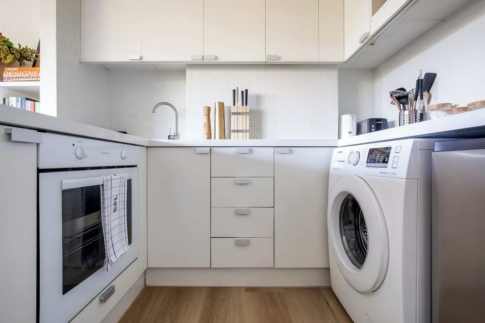 The kitchen includes an induction stove, oven and microwave. The washing machine is also tucked in the kitchen for your convenience. 
