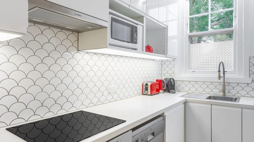 Modern kitchen with sleek cabinetry, tiled splashback and quality appliances