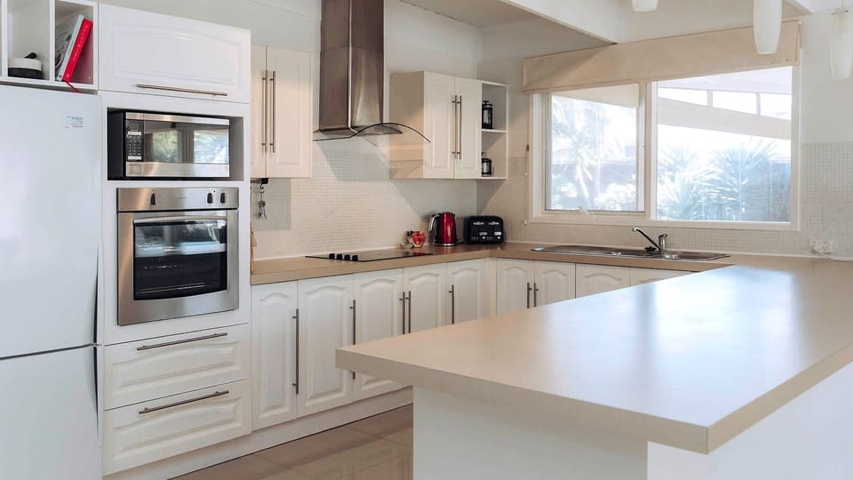An expansive wraparound breakfast bar offers the perfect casual spot for morning coffee and meal prep.