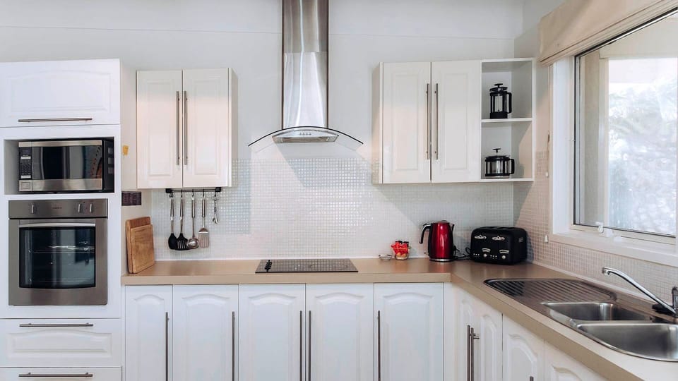 This gourmet, light-filled kitchen boasts integrated stainless steel appliances and crisp white cabinetry.