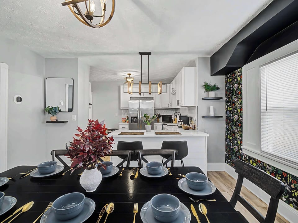 Bright dining table beside the kitchen w/ modern lighting overhead