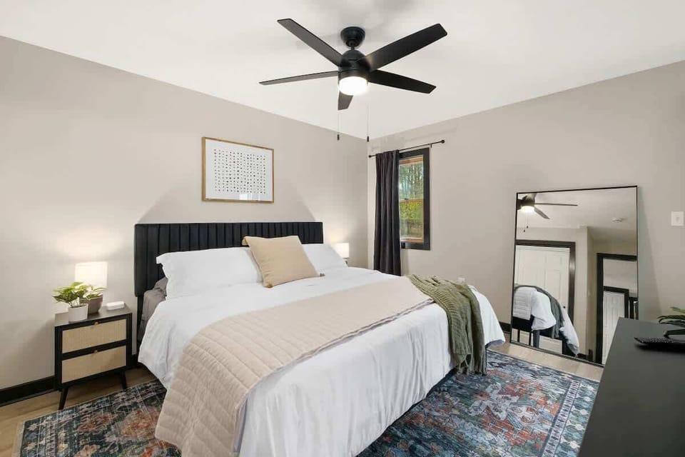 Serene bedroom w/ soft bedding, ceiling fan & calming tones