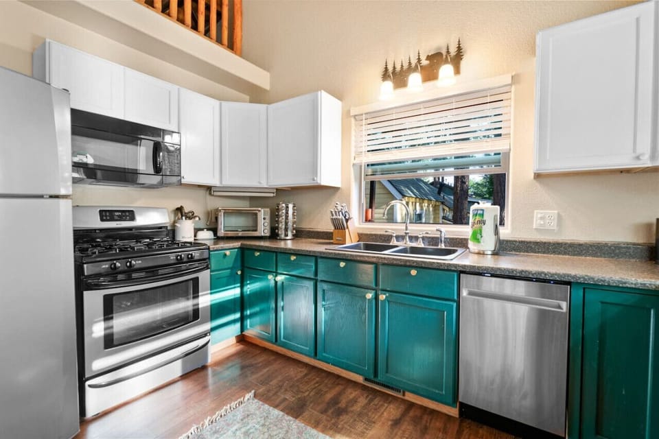 Modern kitchen w/ teal cabinets, full appliances, & plenty of counter space for easy meals.