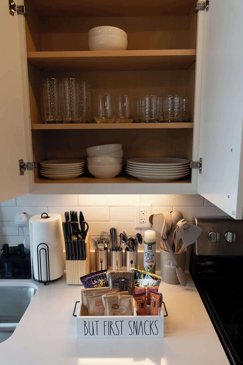 Kitchen cabinet with glasses, dishes, and condiments