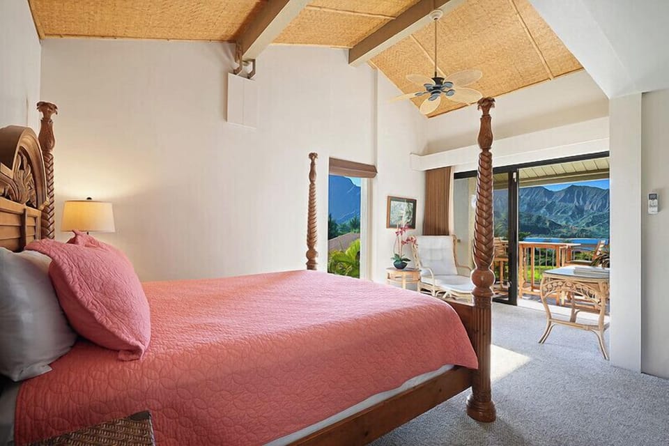 The bedroom features a four-poster bed and stunning mountain views.