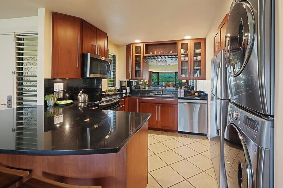 The kitchen has wide counter spaces and stainless steel appliances with an in-unit washer and dryer.