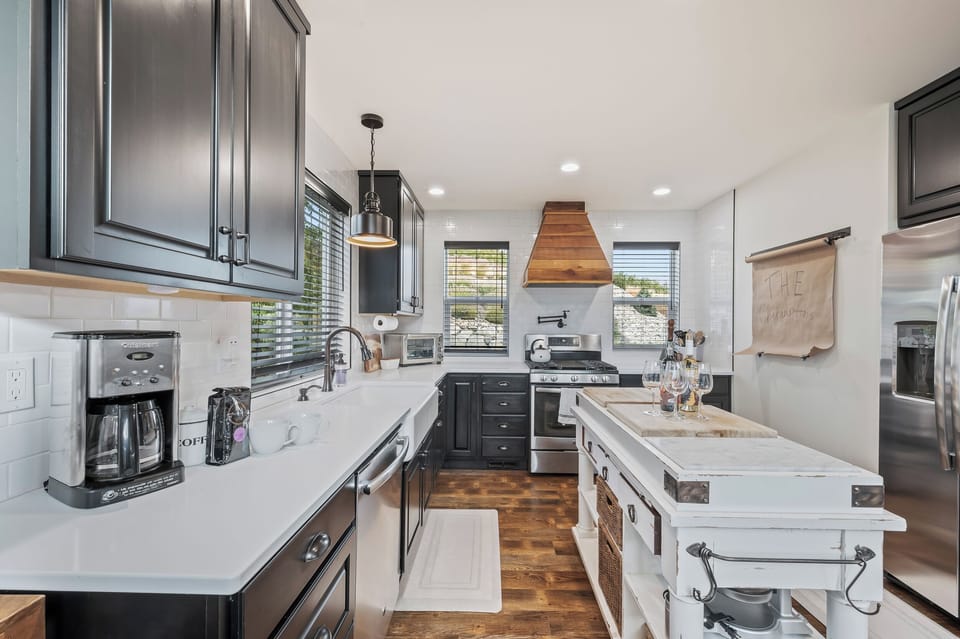 Fully loaded kitchen with 12-cup drip coffee maker, single basin sink, dishwasher, gas range, fridge and freezer