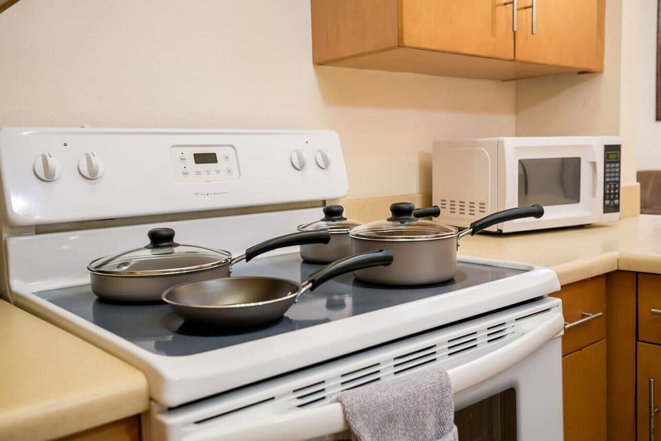 Fully equipped kitchen stove w/ cookware ready for preparing easy meals at home.