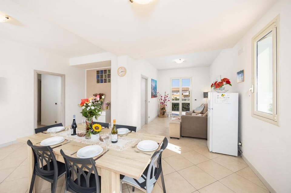 Open-plan living room with sofa, dining area, kitchen, A/C, WiFi internet, and satellite TV