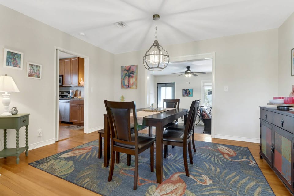 Open to the living room, and leading to the kitchen and sunroom, the dining area is the center of the home .