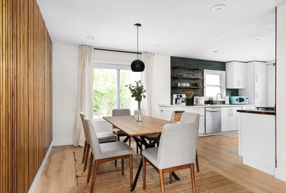 The dining room is an invitation to linger over meals, with an inviting wooden table, cozy seating, and retro decor that blends perfectly with the home’s mid-century charm.