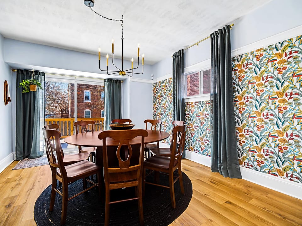 Bright dining space w/ wood floors & statement wallpaper accents