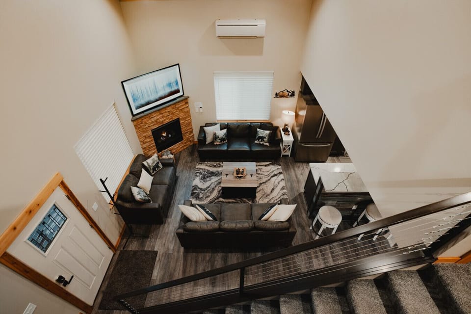 Living Room - View from the loft - Great space for relaxing, watching movies and enjoying time together with 2 sofas, a loveseat, 65` Smart TV & fireplace!