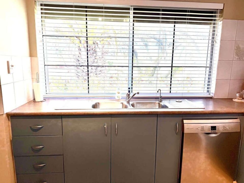 Bright and practical, this well-equipped kitchen offers ample counter space, a large sink, and a dishwasher for effortless cleanup.