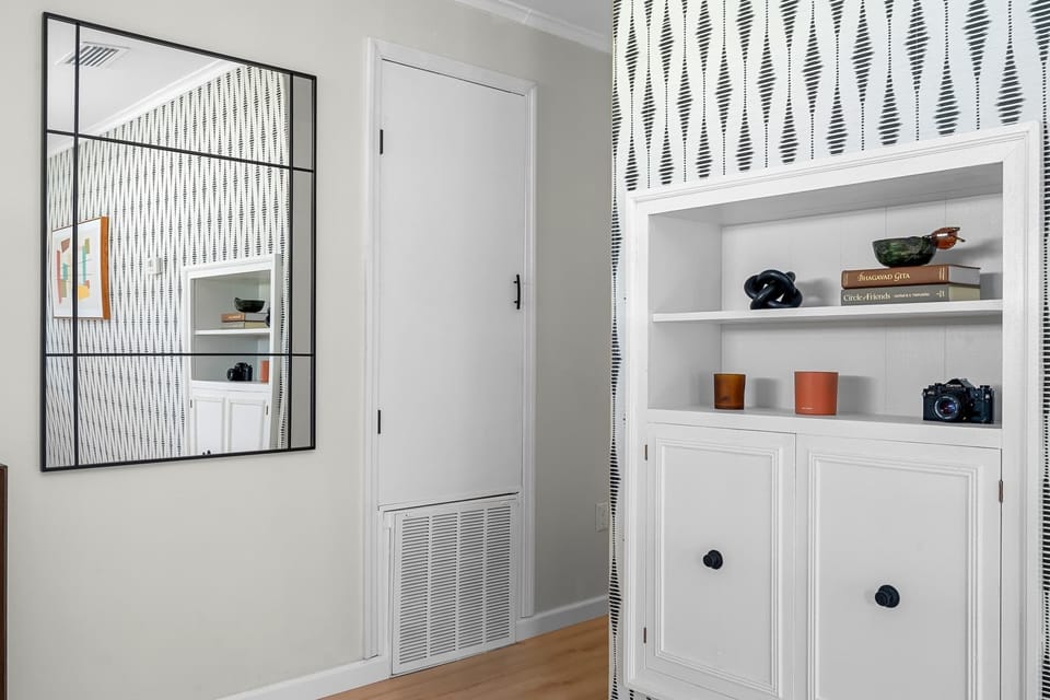 Every corner is a photo-op. Relax in a space designed with an artistic eye, featuring unique geometric wallpaper, mid-century modern inspired built-ins, and a grid-style mirror that adds depth and modern flair to the home.