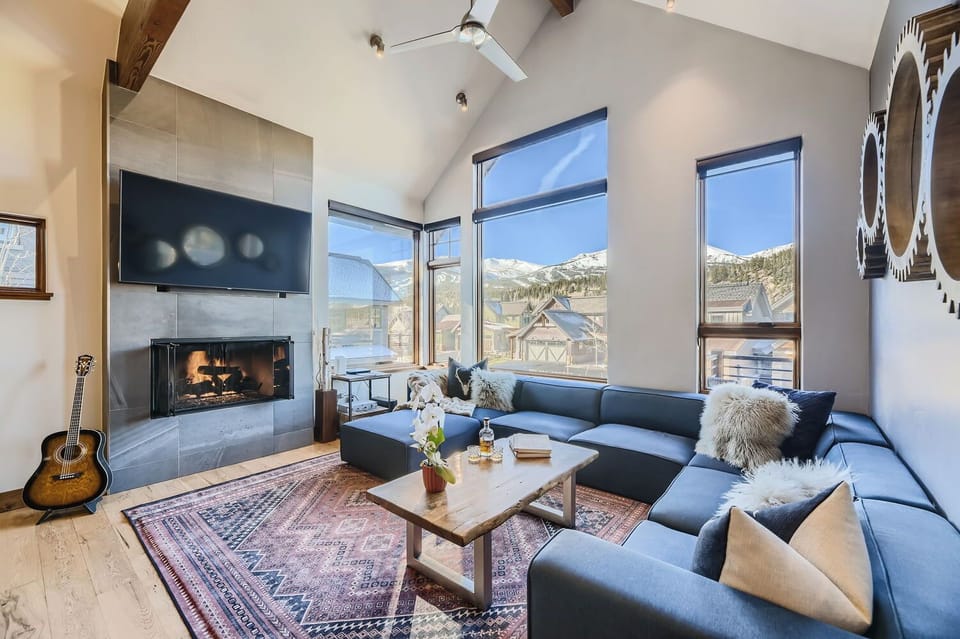 Open light and bright living area with large picture windows and gas fireplace.