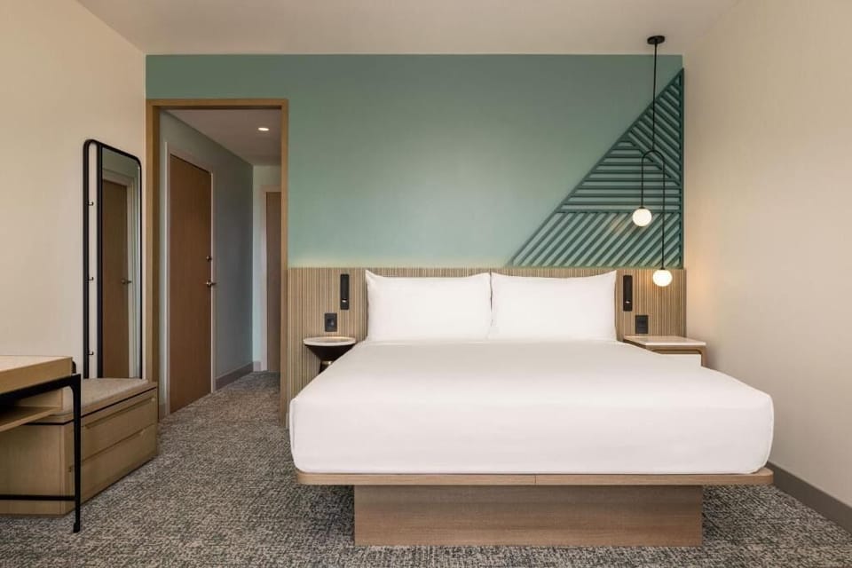 Unwind in crisp linens beneath modern lighting and calming tones.