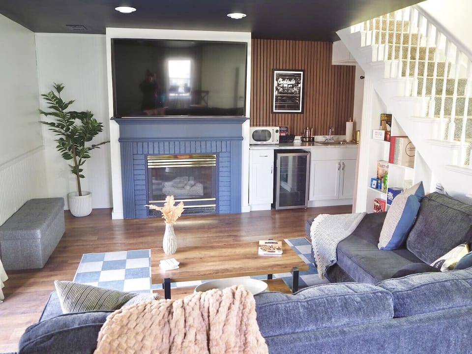 Game room with comfy seating, large screen TV, and fireplace décor.