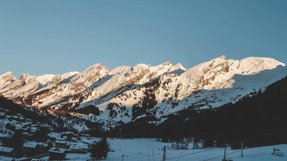 A panoramic view of the snow-dusted Alpine village bathed in warm golden light.