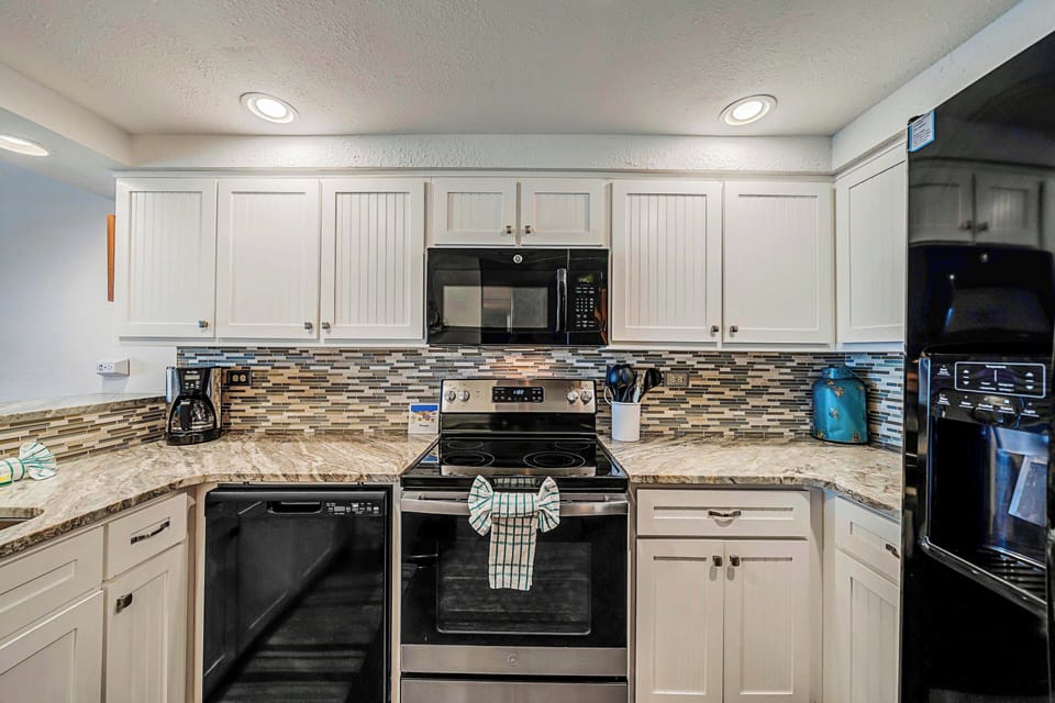 The fully equipped kitchen features granite countertops, updated cabinets & appliances, and has everything you need to prepare meals for family & friends.