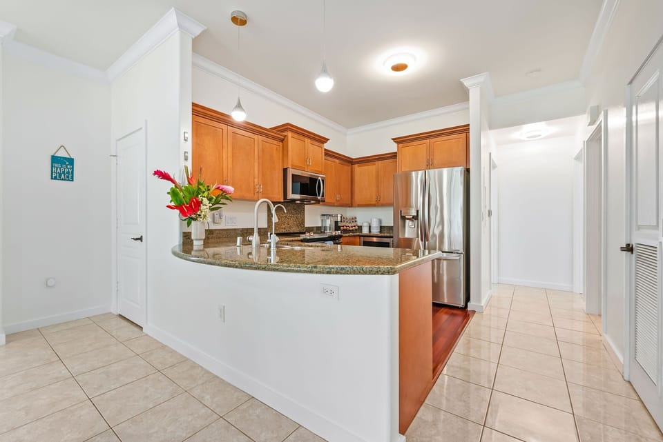Modern kitchen with a granite countertop and stainless steel appliances, perfect for preparing island-inspired dishes.
