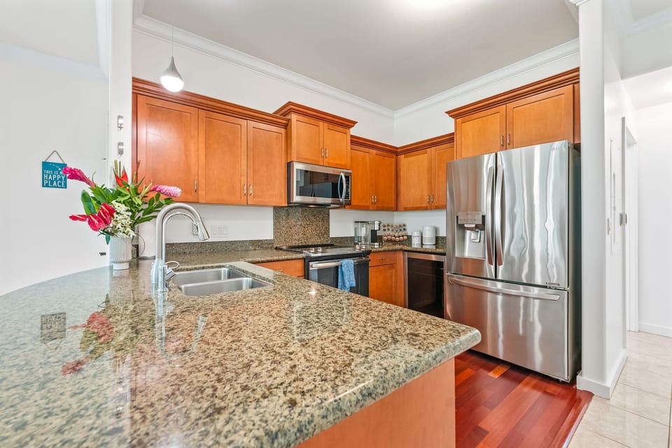 Beautiful granite countertops and wood cabinetry create a warm and welcoming space in this well-equipped kitchen.