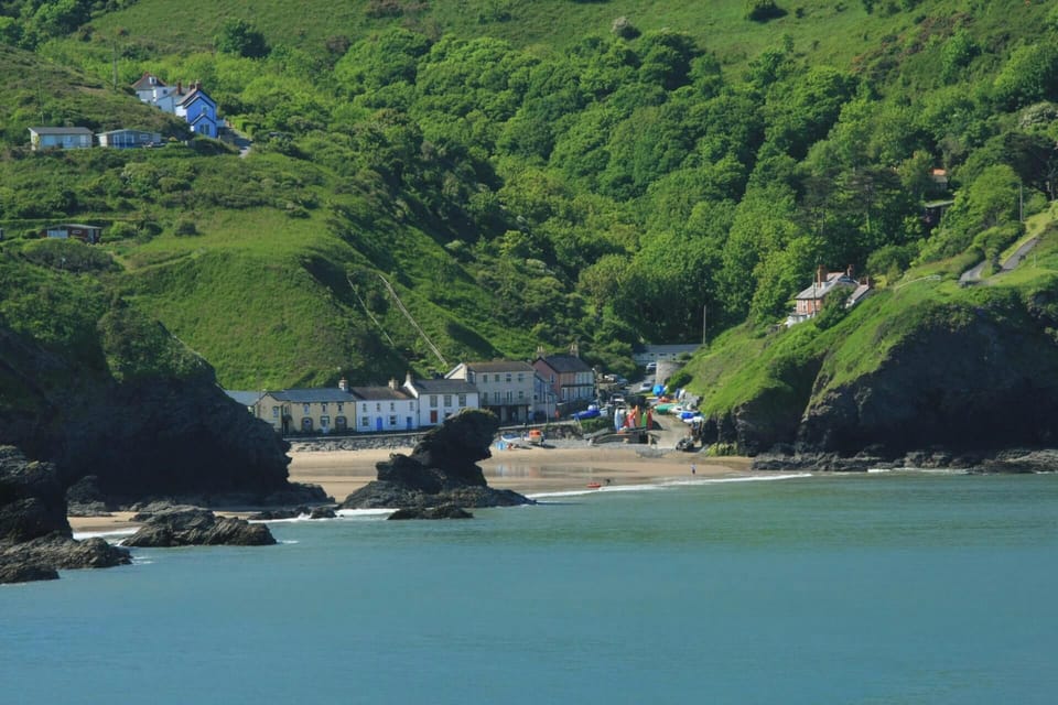 View from the sea of Llangrannog beach with the village and hillside behind