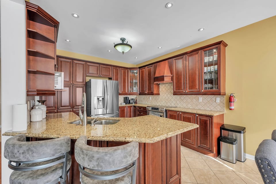 Modern kitchen with stainless appliances e and two bar stools, kitchen cabinets