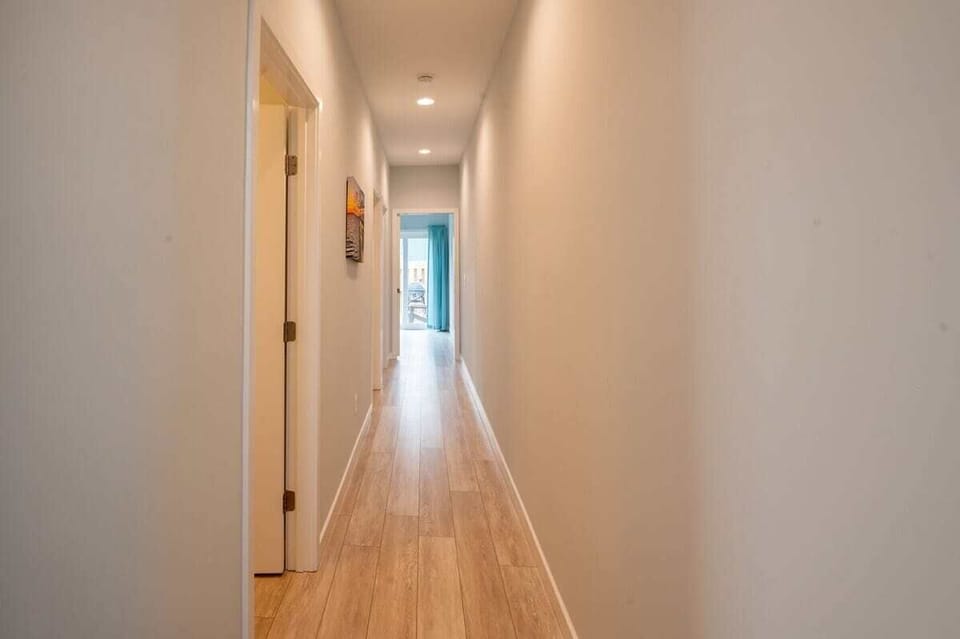Hallway to 2 downstairs bedrooms and back yard