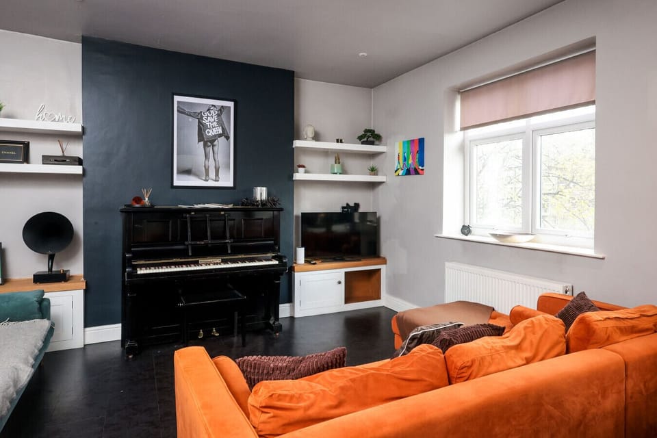 Distinctive living area featuring a beautiful piano and spacious seating arrangement. The bright, well-designed space offers both entertainment and relaxation, ideal for guests who appreciate music and the arts.