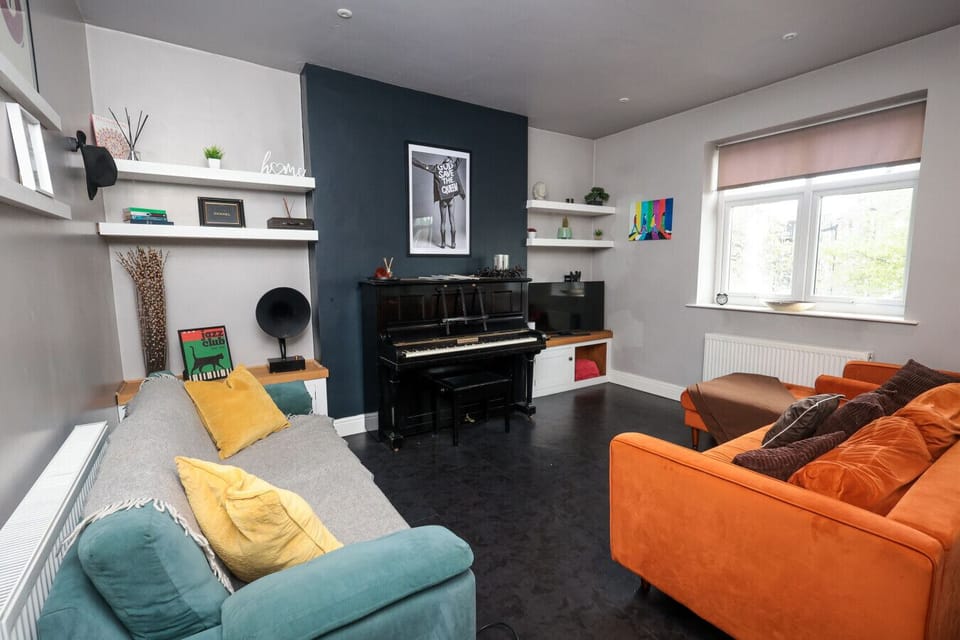 Distinctive living area featuring a beautiful piano and spacious seating arrangement. The bright, well-designed space offers both entertainment and relaxation, ideal for guests who appreciate music and the arts.