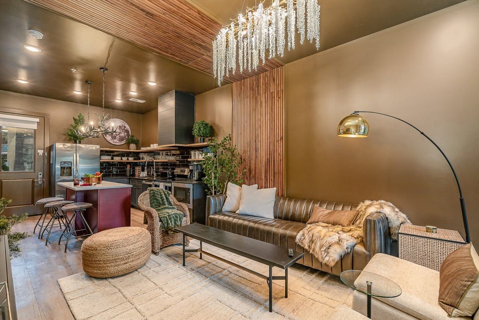 Bright, open living area with a smart flat-screen TV and stylish designer furnishings seamlessly connecting the dining area and kitchen. (1st Floor)