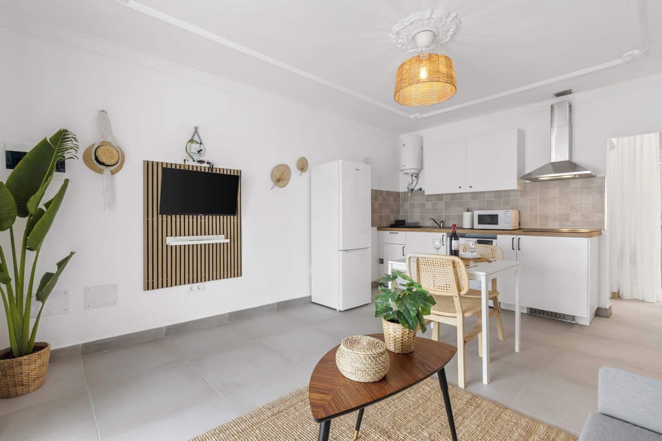 Salón con cocina equipada y comedor, diseño limpio y detalles naturales que invitan a desconectar y disfrutar. 🌿🍷 Aprovecha la comodidad y reserva tu próxima estancia en Palm Sunset.
