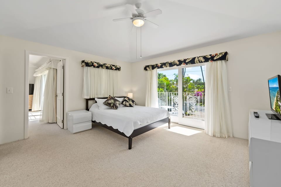 Bright and airy guest suite with large windows, creating a comfortable and inviting space.