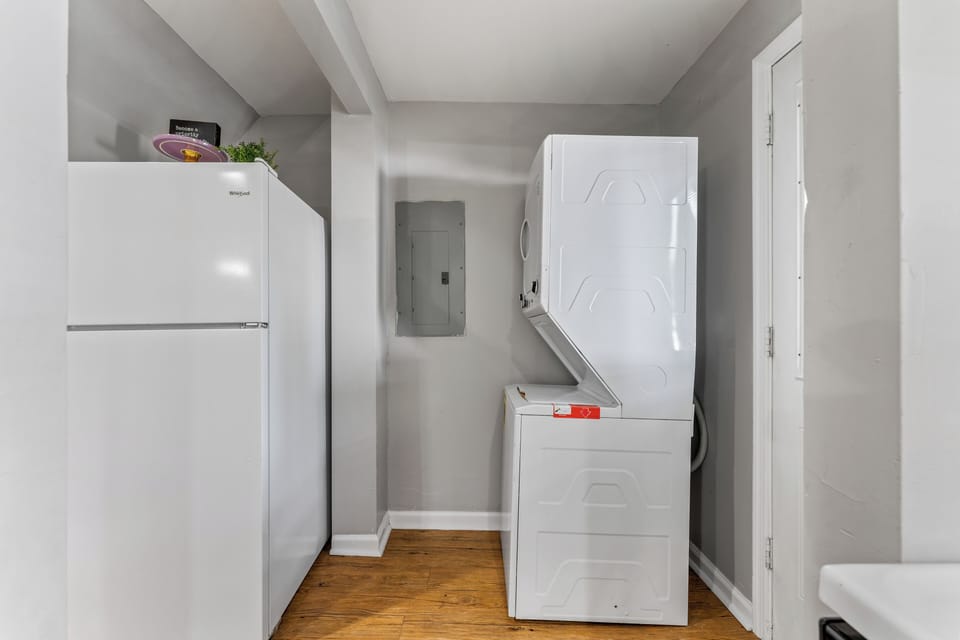 Functional laundry room with a fridge, washer, and dryer.