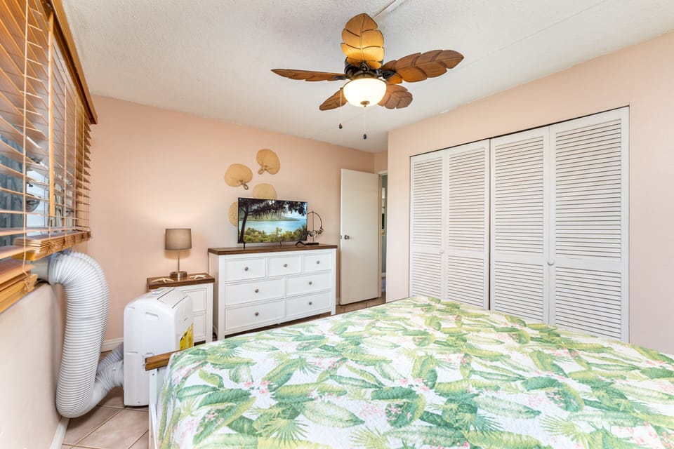 Bedroom with king bed, portable AC, and smart TV