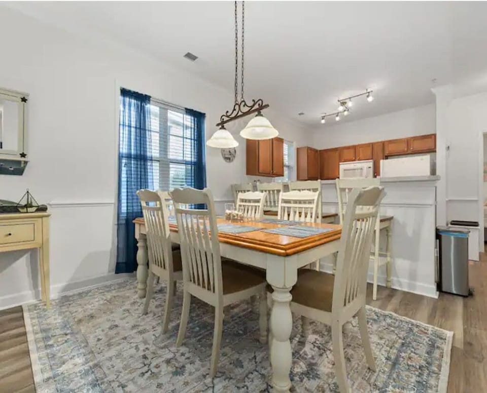 The dining area with 6 seats at the table and 4 bar stools at the breakfast bar.
