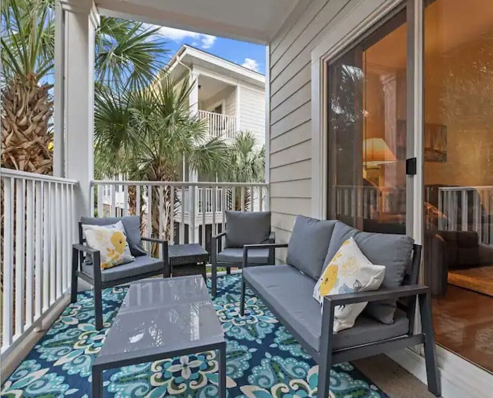 Comfortable seating for four on the private balcony overlooking a wooded area. 
